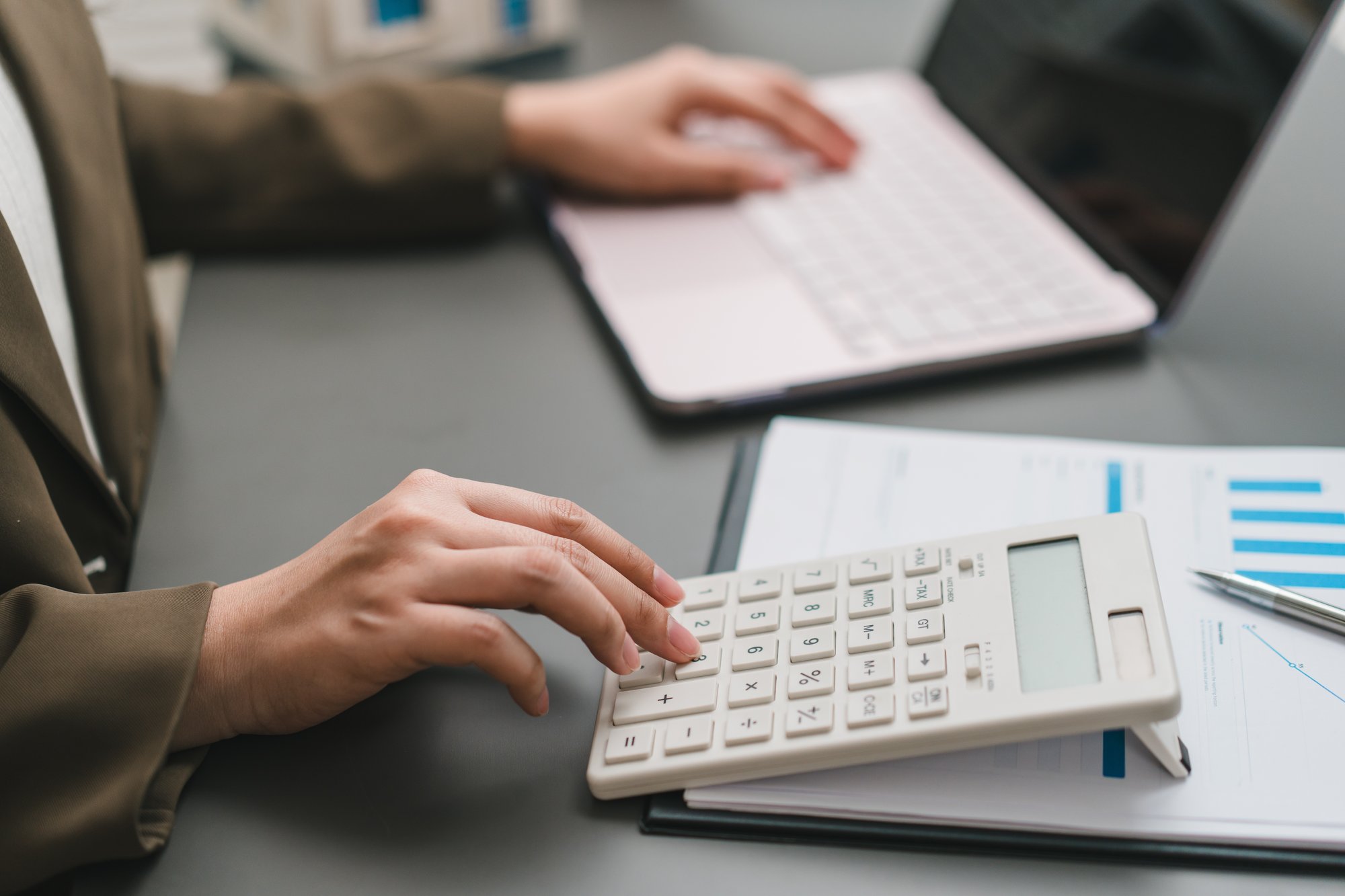 Accountant working on a laptop and calculator.