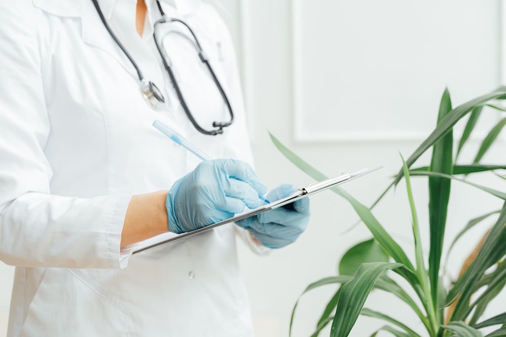 Healthcare professional writing patient notes