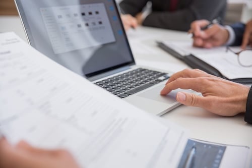 healthcare accountant reviewing financial information on a laptop