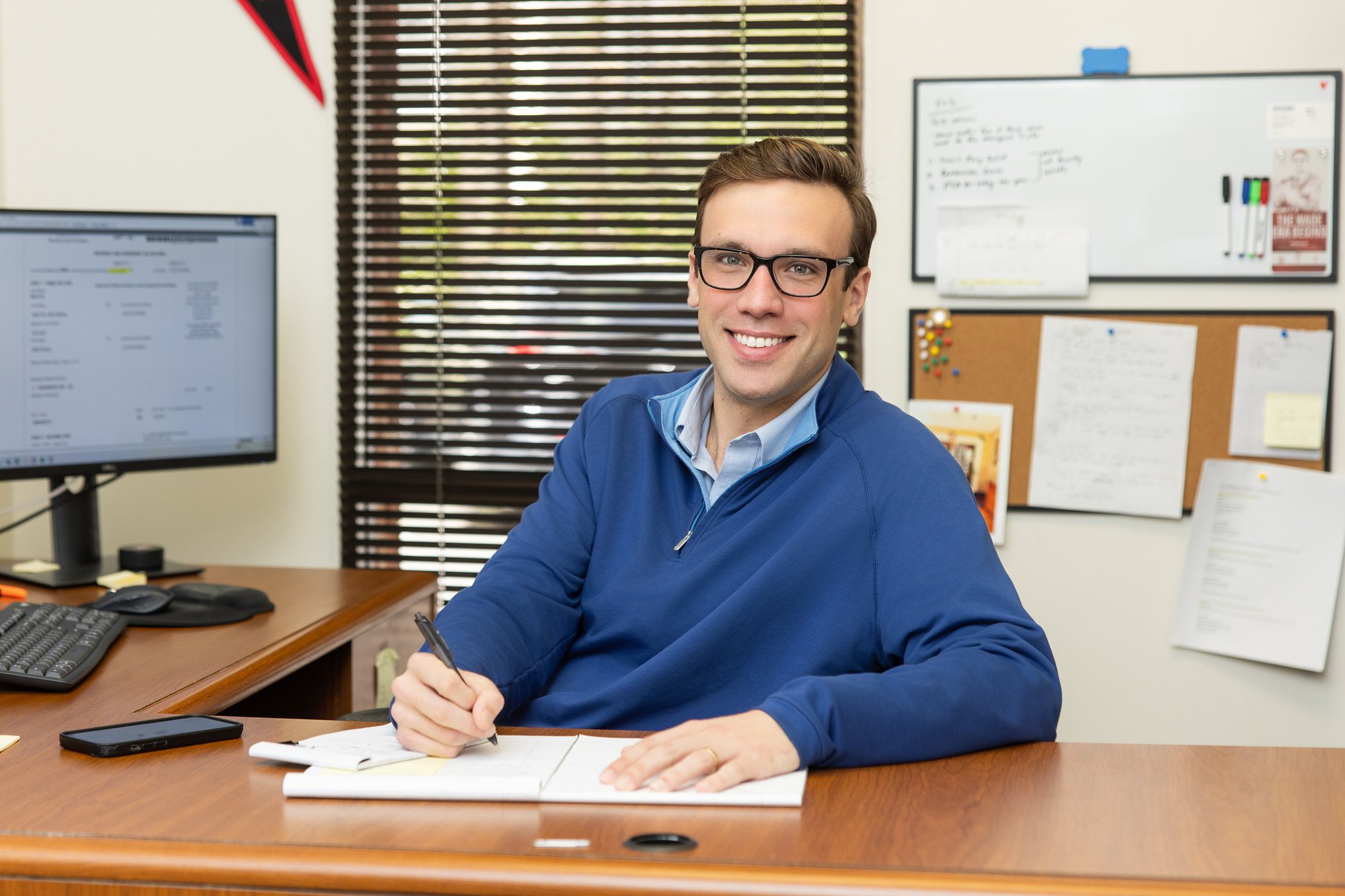 Stancil CPA team member sitting at his desk in a Raleigh office, reviewing financial documents and taking notes.